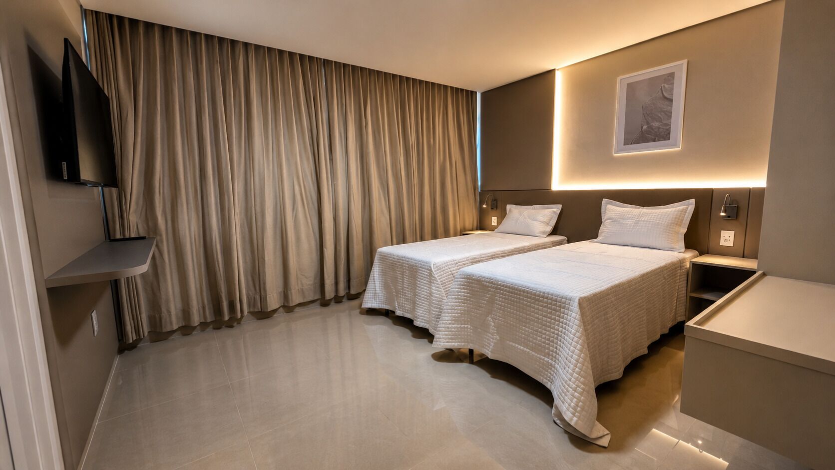 Een hotelkamer met twee bedden, een televisie, een nachtkastje en een aan de muur hangend schilderij.