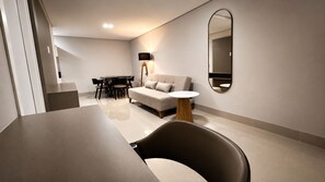 Een moderne woonkamer met een bank, een eettafel en stoelen.