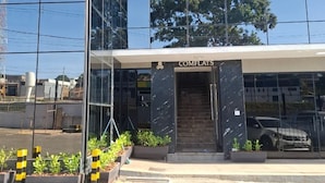 Un bâtiment moderne avec une façade en verre, une entrée couverte et une enseigne indiquant « COMFLATS ».