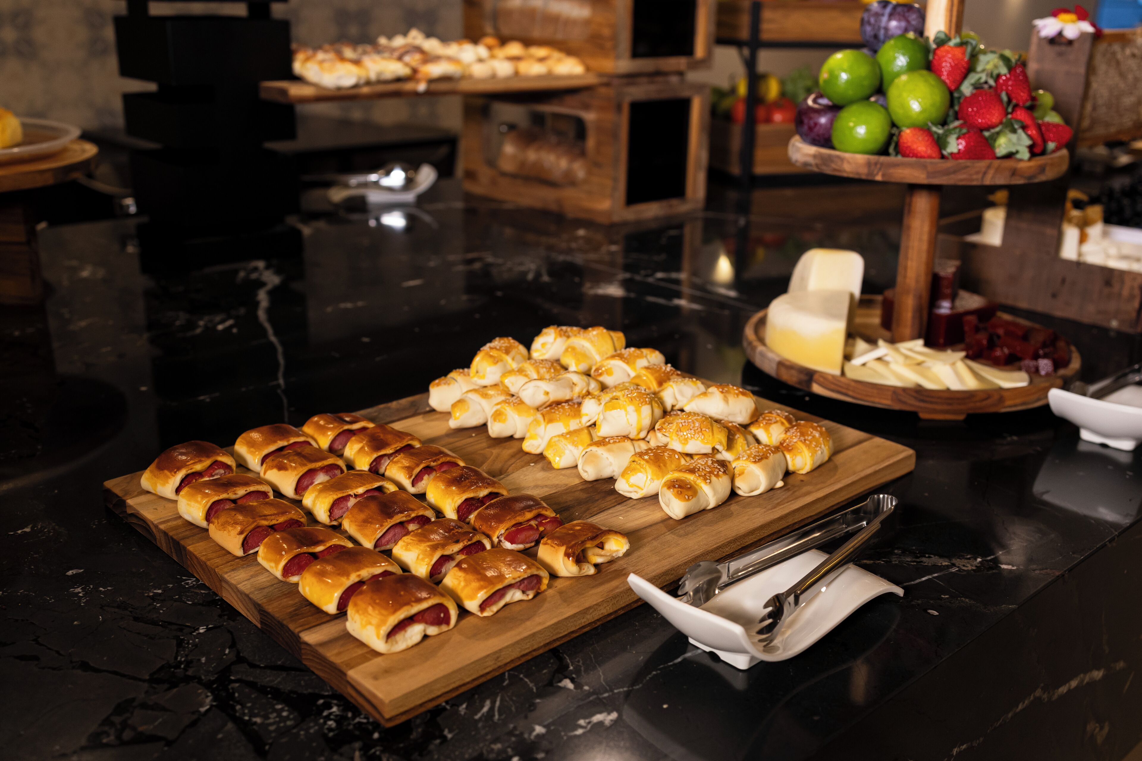 Uma mesa de buffet com diversos alimentos, incluindo doces e frutas.