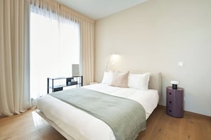 Une chambre dâhĂŽtel avec un lit, un bureau, une lampe et une table de chevet.
