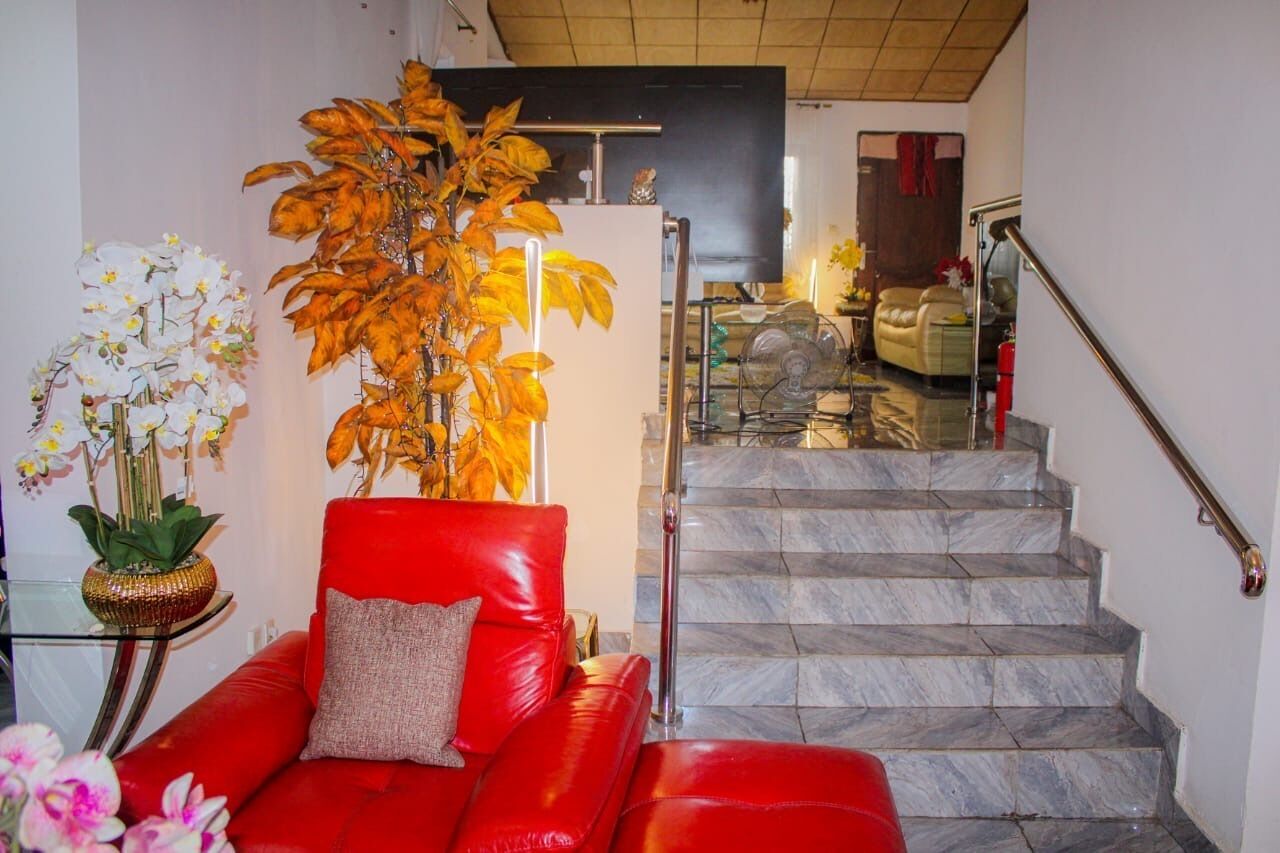 A staircase with marble steps and a red leather sofa with a cushion.