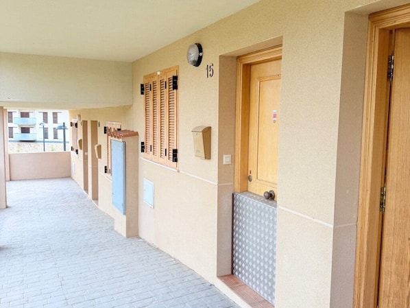 A corridor with doors numbered 15, 16, and 17, a tiled floor, and a small window.