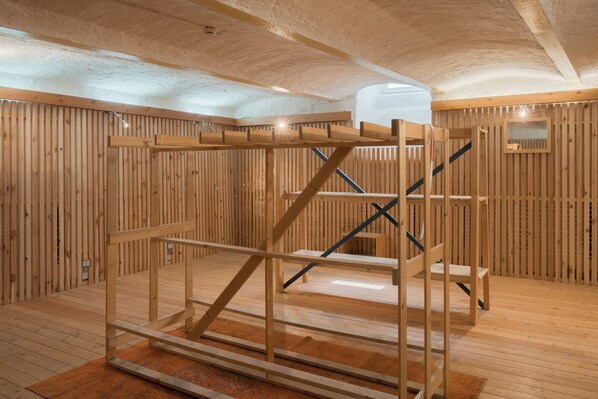 Un interior de madera con una estructura de literas, paredes de madera y un techo abovedado.