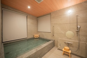 Une salle de bain moderne avec une grande baignoire, une douche et des toilettes.