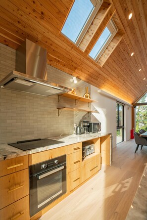 A modern kitchen with wooden cabinetry, stainless steel appliances, and skylights. - Echowoods.  Luxe. Fireplace. Onsen (Hakuba Village, Hokujo)
