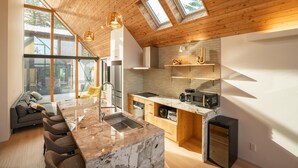 Una cocina moderna con una isla de mármol, techo de madera y tragaluces.