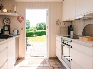 A kitchen with a view of a garden, a heart-shaped decoration, and a coffee maker. - 4 Person Holiday Home in Hejls (Hejls)