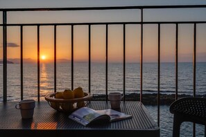A balcony with a table, a bowl of fruit, and a magazine. - Waves - Seaside Escape (Chania)