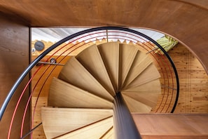 Eine Wendeltreppe mit Holzsitzstufen und Metallgeländern.