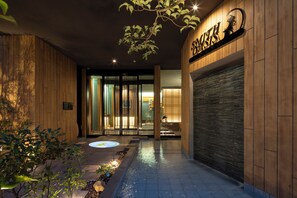 Une entrée moderne avec un revêtement mural en bois, une porte en verre et une enseigne au-dessus de la porte.