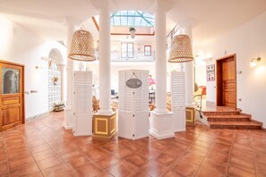 A spacious lobby with a high ceiling, a central column, and a 'WELCOME' sign.