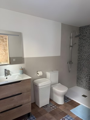 Een moderne badkamer met een wastafel, toilet en douche.