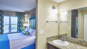 Habitación de hotel con cama, baño con lavamanos y espejo, y vistas al exterior.