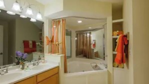 Une salle de bain avec une baignoire, un lavabo et un miroir.