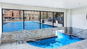 En swimmingpool med utsikt över byggnader och en klar himmel.
