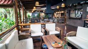 Ein Restaurant mit Holztischen, hängenden Lampen und einer Bar.