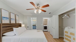 Quarto com cama, ventoinha no teto, cômoda e closet espaçoso.