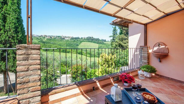 A balcony with a view of a green landscape, a table with a tray of snacks and drinks, and a potted plant. - Casa Greta - Flo Apartments 34 (Montespertoli)