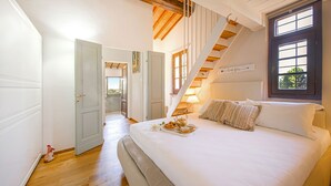 A bedroom with a bed, a tray of food, a staircase, and a door leading to another room. - Casa Greta - Flo Apartments 34 (Montespertoli)