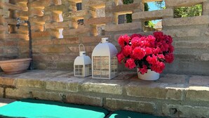 A stone wall with a rustic lantern, a flower pot, and a wooden bowl. - Casa Greta - Flo Apartments 34 (Montespertoli)