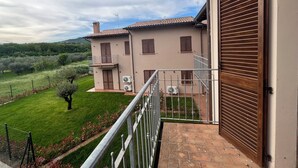 A two-story house with a balcony, a garage, and a well-maintained lawn. - Cozy suite with contemporary design and comfort for 4 guests Suite Aura (Vernazzano Basso)