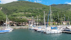 A marina with boats docked, a hillside with buildings, and a clear sky. - Beautiful private villa for 4 guests with WIFI, TV, terrace, pets allowed and panoramic view (Montemezzo)