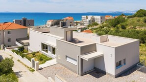 A modern building with a flat roof, large windows, and a view of the sea. - The Adriatic Retreat (Podstrana - Mutogras)