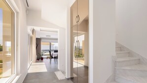 A modern interior with a hallway leading to a dining area and a staircase. - The Adriatic Retreat (Podstrana - Mutogras)