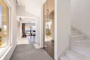 Ein modernes Interieur mit einer Diele, die zu einem Essbereich und einer Treppe führt.