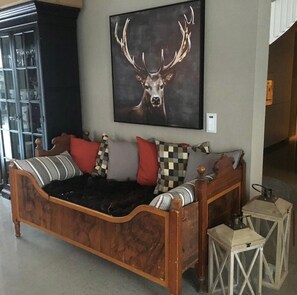 A wooden bed with a headboard, multiple pillows, and a framed deer painting above it. - Cabin in the heart of Sirdal - ski in/ski out, great outdoor area with large jazzuci (Tjørhom)