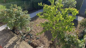 A garden with various plants and a wooden deck. - Maryvonne's House · 4 bedrooms · Southwest Terrace (Saint-Brieuc)