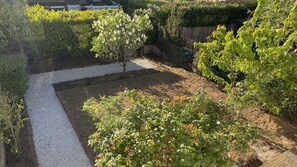 A garden with a gravel path, various shrubs, and a wooden fence. - Maryvonne's House · 4 bedrooms · Southwest Terrace (Saint-Brieuc)