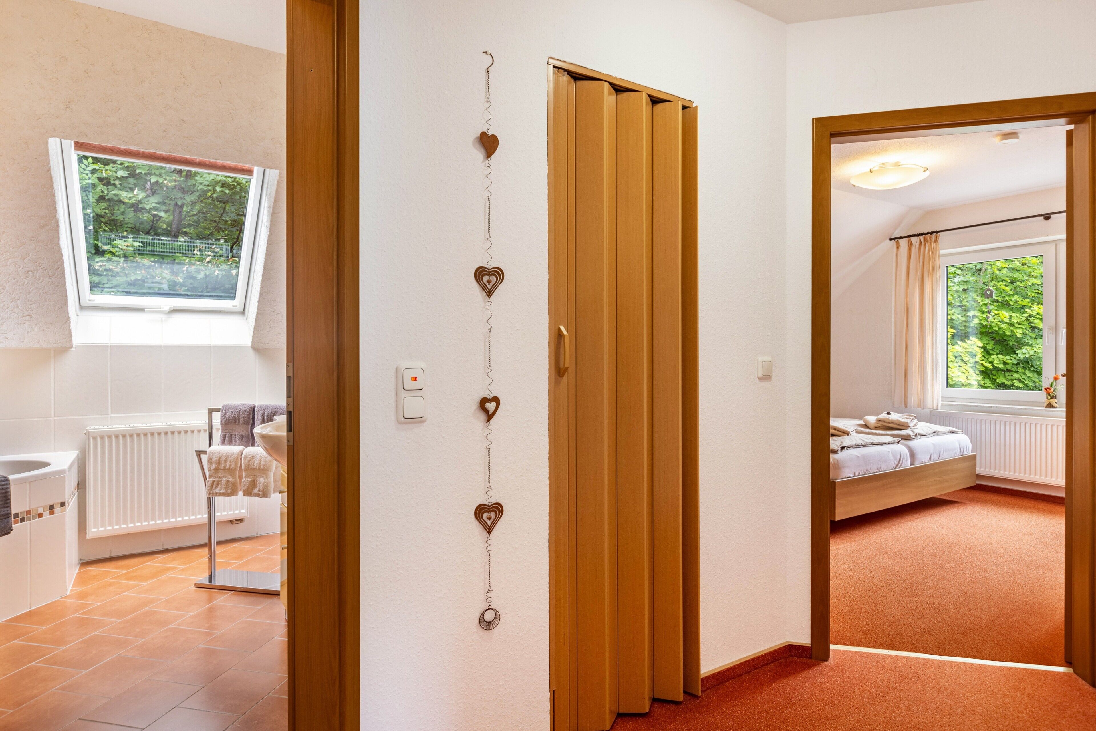 Une chambre à coucher avec un lit, une fenêtre, un radiateur et une salle de bain comprenant un lavabo et des toilettes.
