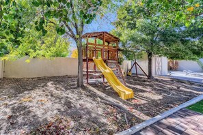 A playground with a wooden slide and climbing structure.