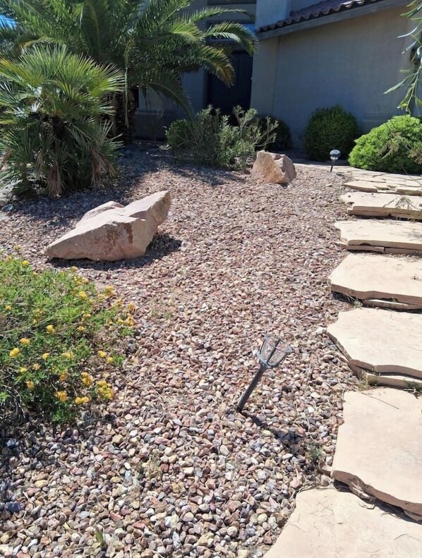A garden with gravel, rocks, and plants.