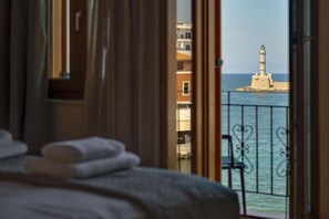 A hotel room with a balcony overlooking a sea and a lighthouse. - Leo - 2 Bedroom Apartment Overlooking (Chania)