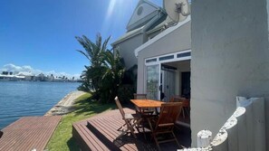 Uma propriedade à beira-mar com varanda, mesa e cadeiras.