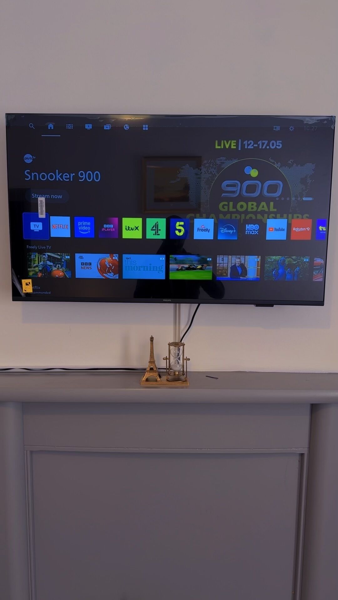 Un téléviseur Snooker 900 fixé au mur, avec une petite maquette de la Tour Eiffel placée en dessous.