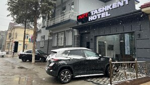 A hotel with a balcony, a sign reading 'Art Tashkent Hotel,' and a black car parked in front. - Elite Art Tashkent (Tashkent)