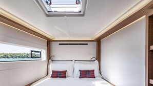 Een kleine kamer met een bed, dakraam en raam.