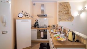 A compact kitchen with a built-in oven, a small refrigerator, and a coffee machine. - Colleoni 20. Superior Apartment. A stylish apartment for 4 people. Upper Town (Bergamo)