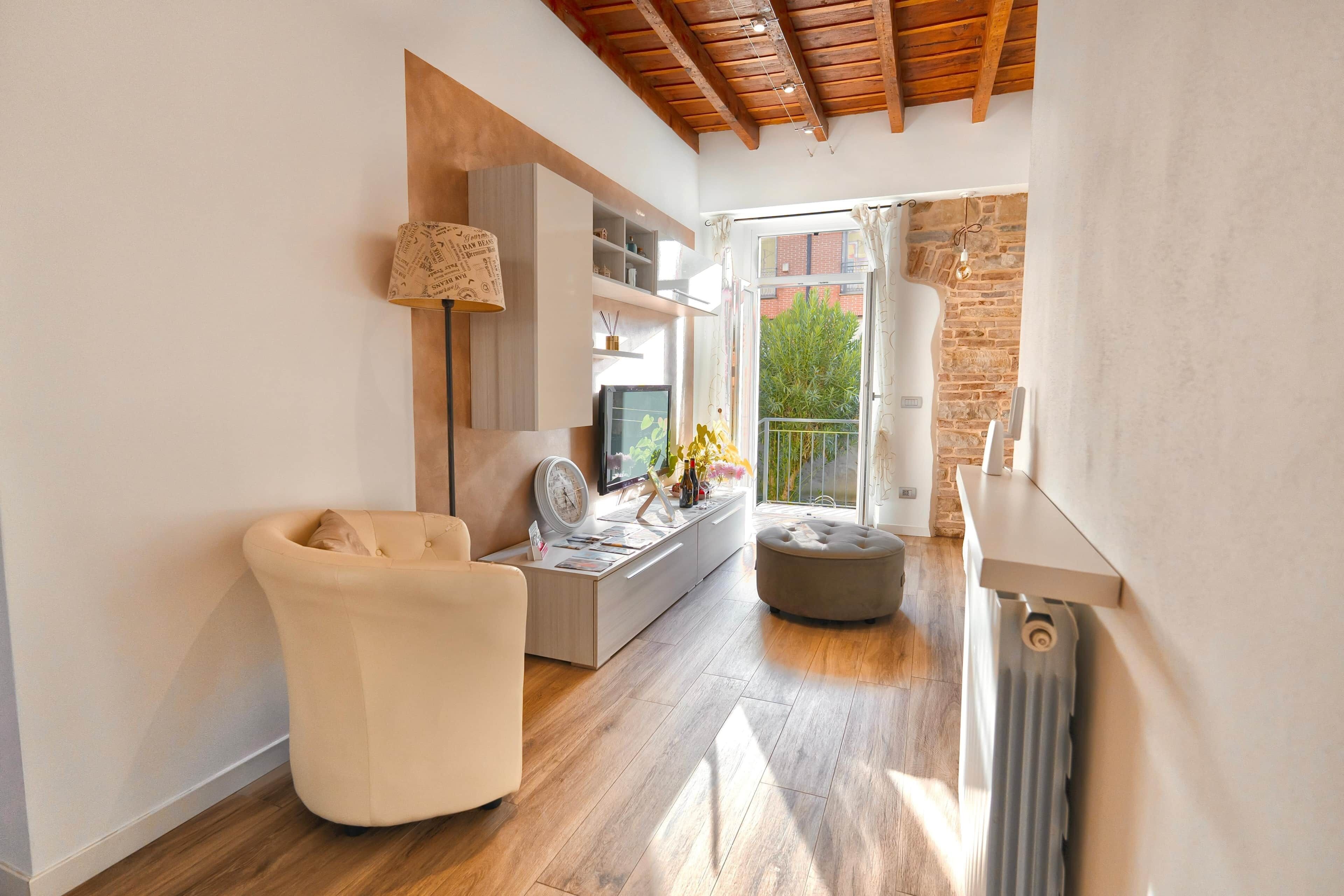 Un salon moderne comprenant un canapé, un téléviseur et un coin repas avec une table et des chaises.