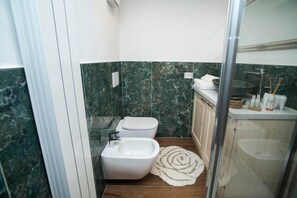 A bathroom with a bidet, toilet, and a shower area. - The Key to Bergamo.  Il Capitello is a stylish apartment located at 112 Via Pignolo (Bergamo)