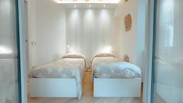 Une chambre avec deux lits, un plafond en bois et une cloison en verre.