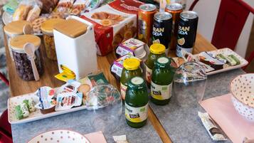 Ein Tisch mit verschiedenen Speisen und Getränken, darunter Gläser, Flaschen und verpackten Waren.