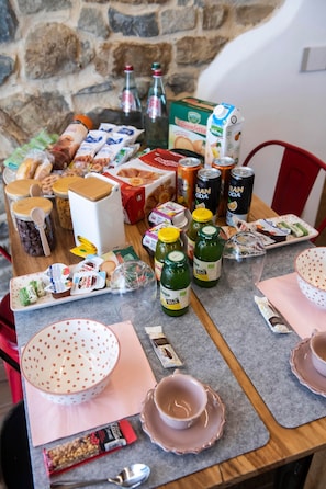 Ein Tisch mit verschiedenen Speisen und Getränken, darunter Gläser, Flaschen und verpackten Waren.