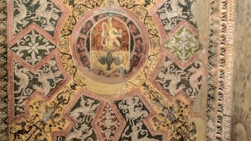 A detailed ceiling with intricate geometric patterns and a central circular design.