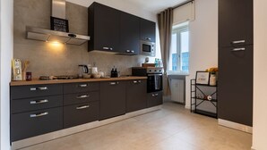 Ett modernt kök med mörka skåp, en gasspis, en mikrovågsugn och en inbyggd ugn.