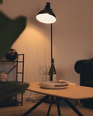 A table with a lamp, wine glasses, and a bottle. - Arena View Modern Stay (Bergamo)